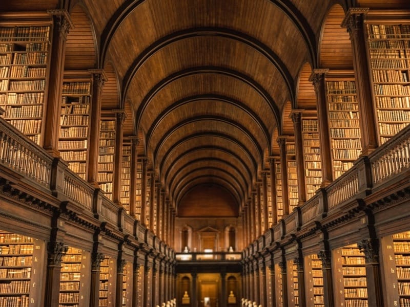 Long arched library hall lined floor to ceiling with old books