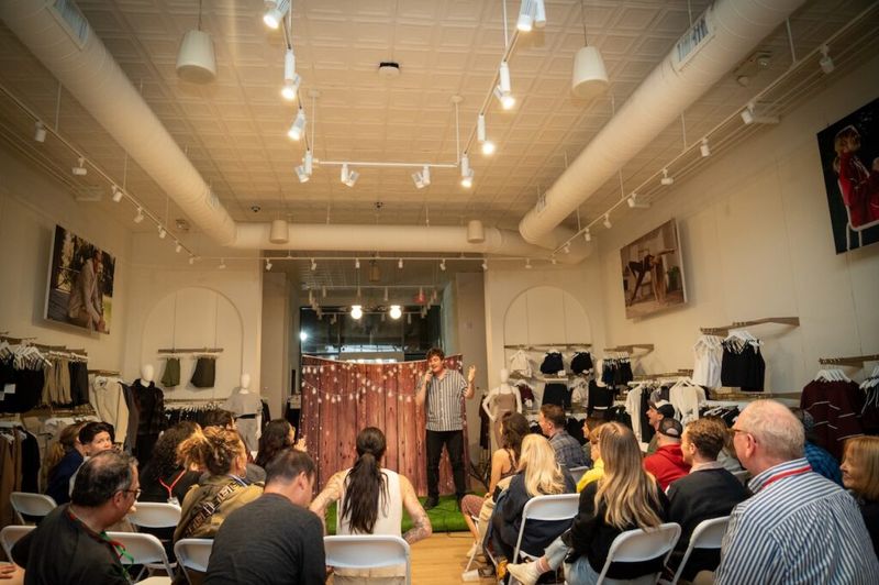A comedian performs to a full audience inside the Beyond Yoga store during the comedy crawl.